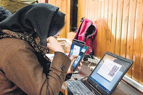 A female journalist uses internet on her mobile phone after the government restored internet services in Srinagar | Pti