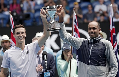 Rajeev Ram, right, of the U.S. and partner Britain's Joe Salisbury hold their trophy aloft after defeating Australia's Max Purcell and Luke Saville in the men's doubles final at the Australian Open. (Photo | AP)