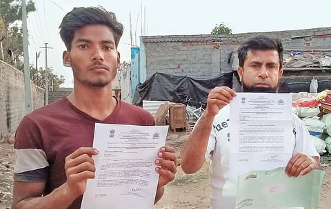 Mohd Zuwail and Nazeerul Islam showing the notices served by UIDAI