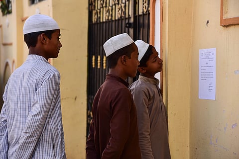 Residents of Balapur reading the UIDAI notice regarding the postponment of the enquiry . (Photo | Vinay Madapu/EPS)
