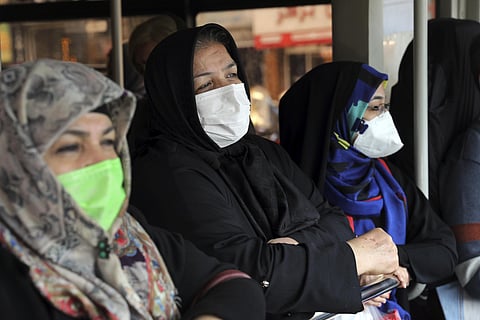 Commuters wear masks to help guard against the Coronavirus on a public bus in downtown Tehran. (Photo | AP)