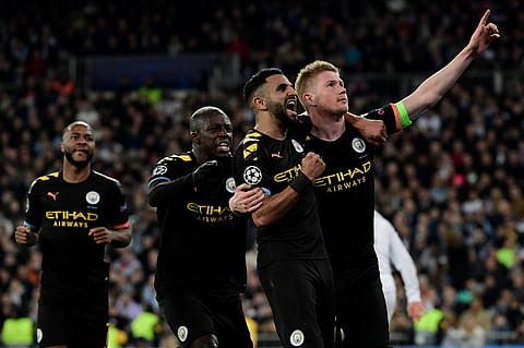 Manchester City's Belgian midfielder Kevin De Bruyne (R) celebrates his goal with teammates during the UEFA Champions League round of 16 first-leg football match between Real Madrid CF and Manchester City at the Santiago Bernabeu stadium in Madrid on Febr