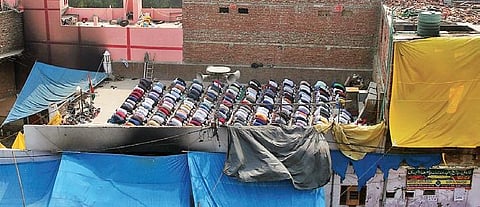 People offer prayers on the rooftop of a mosque, damaged by rioters. (Photo | Shekhar Yadav, EPS)