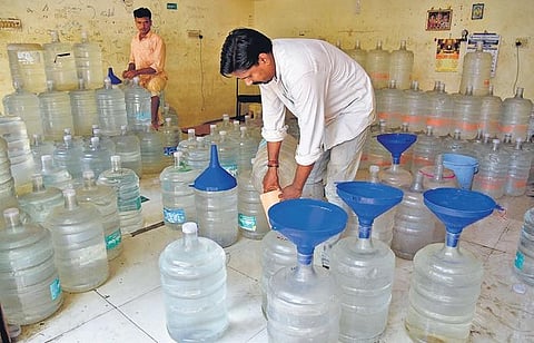 Residents filling their water cans at wholesale shops on Friday| R Satish Babu