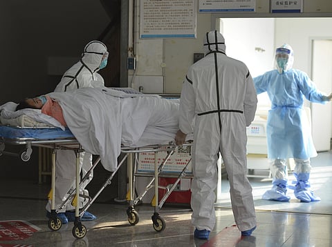 Medical workers in protective suits move a coronavirus patient into an isolation ward at the Second People's Hospital in Fuyang in central China's Anhui Province, Saturday, Feb. 1, 2020. (Photo | AP)
