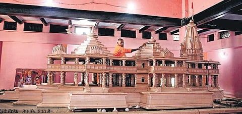 A Kar Sevak cleans a model of the Ram Temple at Kar Sevakpuram in Ayodhya. (File Photo)