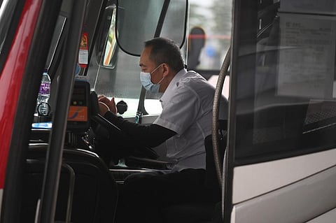 A bus driver wearing a facemask as a preventative measure following a coronavirus outbreak which began in the Chinese city of Wuhan, rests in his bus at Shenzhen Bay Port Hong Kong Port Area on February 8, 2020. (Photo | AFP)