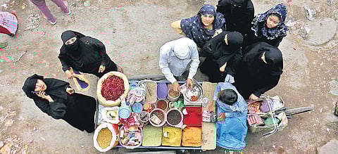 Women buy spices from a vendor in Mustafabad.