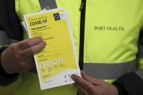 Staff hand out leaflets as part of a public awareness campaign for COVID-19 in the baggage hall of Terminal 2 at Dublin Airport, Dublin, Friday, Feb. 28, 2020. (Photo | AP)