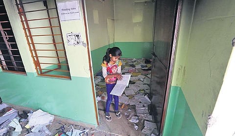 A girl collects books at Rajdhani Public School at riot-hit Shiv Vihar. (Photo | EPS)