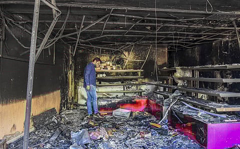 A man stands in a burnt shop which was set ablaze by rioters in a violence-affected area of Northeast Delhi. (Photo | PTI)