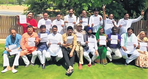 The 19 Madhya Pradesh rebel Congress MLAs pose with their resignation letters in Bengaluru on Tuesday. (Photo | EPS)