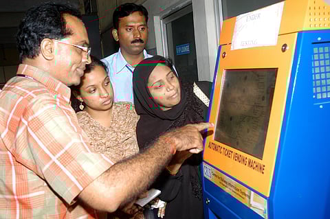 A railway official explaining the usage of smart card machine for getting train tickets to commuters at Tambaram station. (Photo | J Manoharan, EPS)