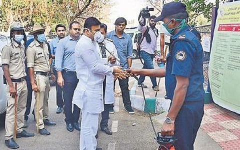 An RGICD hospital staffer sanitises Medical Education Minister Dr K Sudhakar in Bengaluru on Friday | Shriram B N