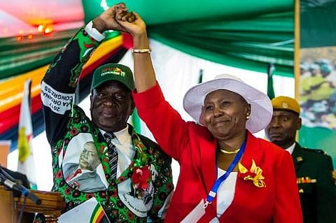 Zimbabwe's President Emmerson Mnangagwa lifts the hand of Oppah Muchinguri Kashiri . (Photo | AFP)