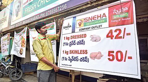 A chicken vendor erects a new rate board in front of his shop after the prices of poultry plummet in the State (Photo | Vinay Madapu, EPS)