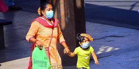 A woman and her daughter cover their faces with masks in Bengaluru amid the coronavirus scare which has claimed a life in the state. (Photo| Pandarinath B, EPS)