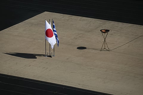 The Japanese flag flies next to an altar with the Olympic Flame of the Tokyo 2020 Olympic Games, inside the Panathenian stadium, in Athens. (Photo | AP)