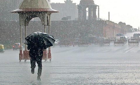 A man shields himself as heavy rains accompanied by hailstorm lashed parts of the national capital, near Vijay Chowk in New Delhi. (Photo| EPS/Shekhar yadav)