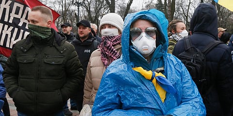 Protesters in face masks take part in a rally in front of the parliament building in Kyiv, Ukraine. (Photo| AP)