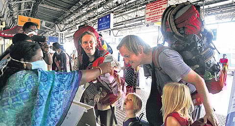 Police officials checking foreign tourists with the help of flash thermometer at the Ernakulam Junction railway station | A Sanesh