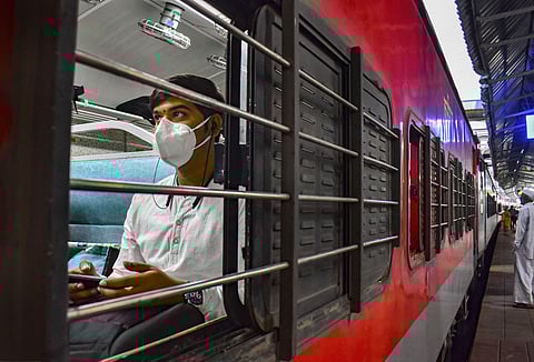 A passenger wearing a protective mask sits inside a train in Solapur. (Photo | PTI)