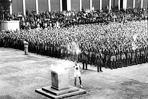 FILE - In this Aug. 1, 1936, file photo, the lighting of the Olympic fire in Lustgarten, Berlin, where it will be guarded by members of the Hitler Youth until it is brought to the Olympic stadium for the opening of the games in the afternoon. (Photo | AP)