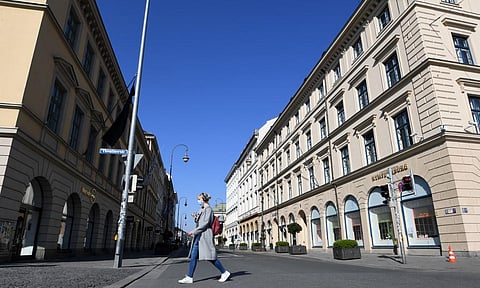 A woman with a protection mask passes a street in the city of Munich, southern Germany, on March 19, 2020. (Photo | AFP)