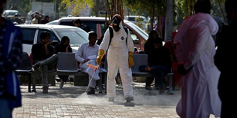 A worker wears protective gear as he sprays disinfectant as a precaution against the new coronavirus, at the Pakistan Institute of Medical Sciences Hospital, in Islamabad. (Photo| AP)
