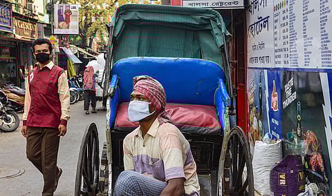 A rickshaw puller wears a mask as a preventive measure against the novel coronavirus in Kolkata Wednesday March 18 2020. (Photo | PTI)