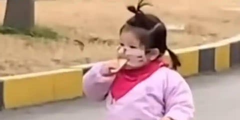 The video captures the little girl munching on a biscuit - without realising she has a face mask on and then looking puzzled as she doesn't quite taste anything. (Photo | People's Daily, China Twitter)