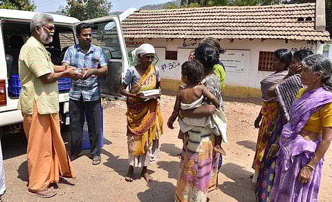 M Balachandar distributing free lunch tribals in Anaikatti Hill | EXPRESS