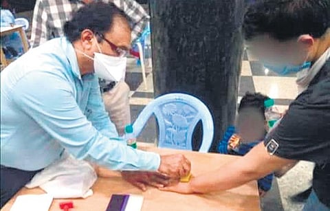 Authorities stamping ‘Home Quarantine’ information on international passengers at Kempegowda International Airport in Bengaluru on Thursday