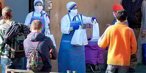 Nuns of the Contemplative Sisters of Mother Teresa distribute food to people in need in Rome on Friday. (Photo| AP)