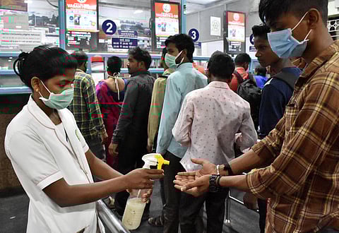 A Medical Staff spraying hand sanitiser to the Passengers at Coimbatore Junction railway station on Friday. (Photo | U Rakesh Kumar/EPS)