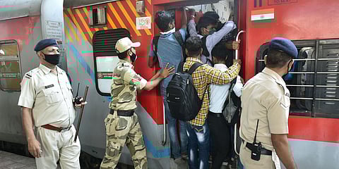 Passengers board a crowded train amid coronavirus scare in Thane on Saturday. (Photo| PTI)