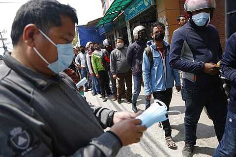 Nepalese men line up outside a pharmacy to buy face masks which are in high demand due to COVID-19 situation in Kathmandu, Nepal, Friday, March 20, 2020. (Photo | AP)