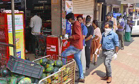 People standing in queue in front of the grocery store fearing the close down in the wake of Corona virus spreading, in Kozhikode. (Photo | Manu R Mavelil, EPS)