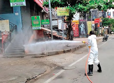 A GHMC worker spraying disinfectants on a road in Hyderabad on Monday