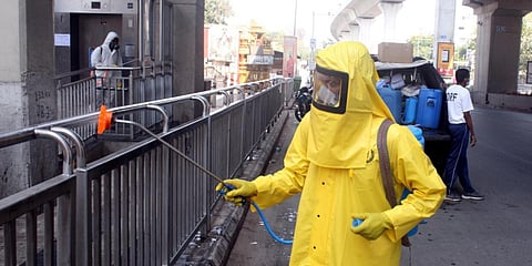 GHMC's Disaster Response Force worker seen spraying disinfectant at ESIC metro station in Hyderabad on Tuesday. (Photo| Sathya Keerthi, EPS)