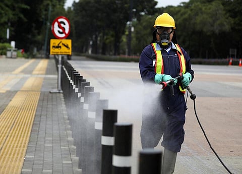 A worker sprays disinfectant at the pedestrian walkway at Senayan Sports Complex amid coronavirus outbreak, in Jakarta, Indonesia. (Photo | AP)