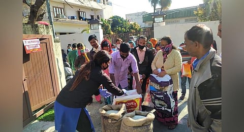Kin of Mahendra Adhikari distributing food items in Haldwani. (Photo | EPS)