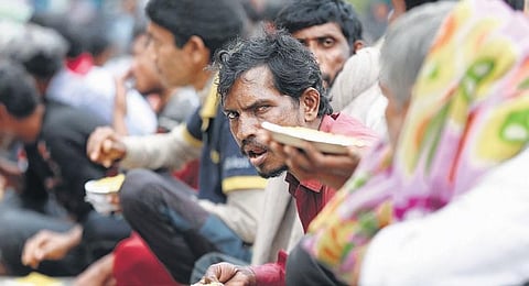 Homeless, daily wagers have a meal at a government shelter. (Photo | Shekhar Yadav, EPS)