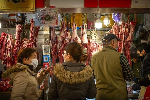 People wear face masks as they shop for meat at a market in Beijing, Saturday, March 14, 2020. (Photo | AP)