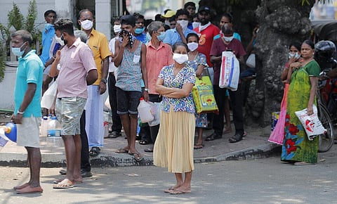 Sri Lankans queue for kerosine oil along a road during a temporary lift of a curfew as virus-containment measures in Colombo, Sri Lanka, Tuesday, March 24, 2020. (Photo | AP)