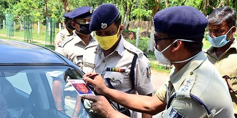 Cops issuing a pass for a commuter who broke curfew in Bhubaneswar. (Photo | EPS)