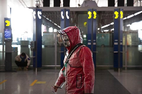 A traveler wears a respirator, goggles, and a raincoat as he walks through Beijing Capital International Airport in Beijing, Saturday, March 28, 2020. (Photo | AP)