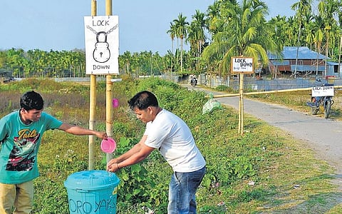 People in a Tripura village wash their hands before crossing a barricade. (Photo | Abhishek Saha/EPS)