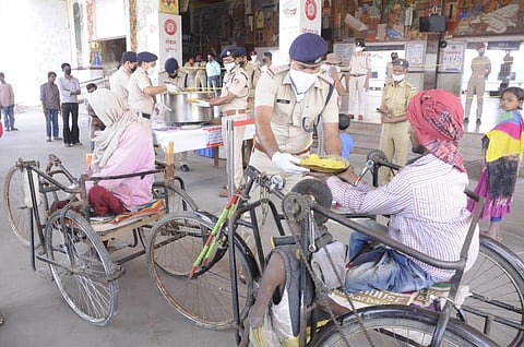 RPF personnels distribute food among the poor, homeless people near Patna junction. (Photo | Ranjit K Dey, EPS)