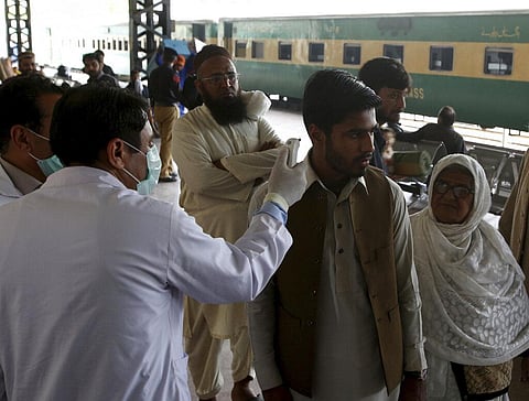 Pakistani volunteers check the body temperature of passengers arriving at a railway station in Peshawar, Pakistan, Tuesday, March 17, 2020. (Photo | AP)